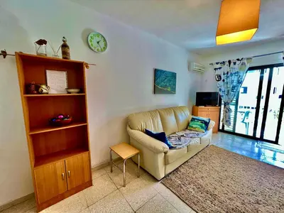 a living room with a couch and a clock on the wall at TaniAndres apartments in Paralimni