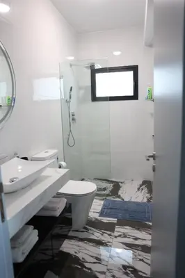 a bathroom with a toilet and a sink and a shower at Όμορφο καινούργιο διαμέρισμα σε μικρή πολυκατοικία in Voroklini