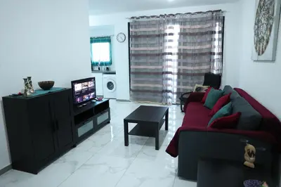 a living room with a couch and a television at Όμορφο καινούργιο διαμέρισμα σε μικρή πολυκατοικία in Voroklini