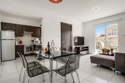 a kitchen and dining room with a table and chairs at Lovely 2 Bedroom Family Apartment w/ Pool in Protaras