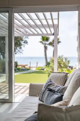 a couch in a living room with a view of the ocean at The MedView Garden House in Pervolia