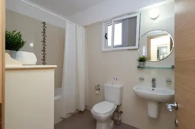 a bathroom with a toilet and a sink and a mirror at Nissi 3 C14 Sea View Top Floor Apartment in Ayia Napa