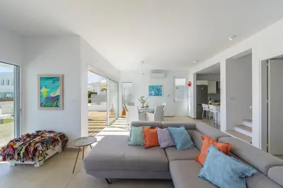 a living room with a gray couch with colorful pillows at Oceania Villa in Protaras