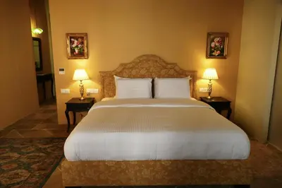 a bedroom with a large white bed with two lamps at Madama Residence in Nicosia