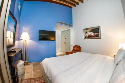 a bedroom with a white bed and a blue wall at Madama Residence in Nicosia