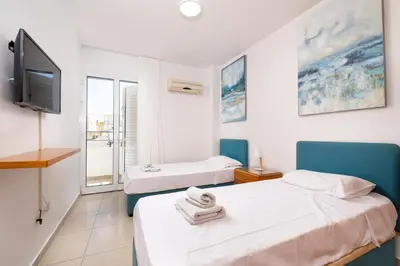 two beds in a room with a tv and a room at The Saline Views Makenzy in Larnaka