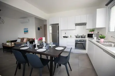 a kitchen and dining room with a table and chairs at Carme at the Beach - Mythical Sands in Paralimni