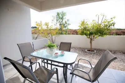 a patio with a table and chairs on a patio at Carme at the Beach - Mythical Sands in Paralimni