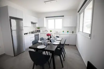 a kitchen and dining room with a table and chairs at Carme at the Beach - Mythical Sands in Paralimni