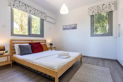 a bedroom with a bed and two windows at Kmeidos 1-Bedroom Apartment in Larnaca in Larnaka