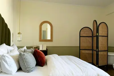 a bedroom with a bed with pillows and a mirror at The Agora Hotel - Small Luxury Hotel of the World - Adults Only in Pano Lefkara