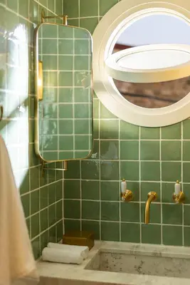 a green tiled bathroom with a mirror and a sink at The Agora Hotel - Small Luxury Hotel of the World - Adults Only in Pano Lefkara