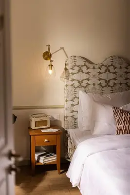 a bedroom with a bed and a table with a telephone at The Agora Hotel - Small Luxury Hotel of the World - Adults Only in Pano Lefkara