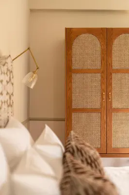 a bedroom with a wooden cabinet next to a bed at The Agora Hotel - Small Luxury Hotel of the World - Adults Only in Pano Lefkara
