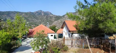 a house with a fence and mountains in the background at Limeria in Alona