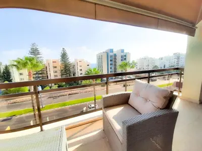 a balcony with a couch and a large window at Samson Sea Breeze, 3bed sleeps 6, free WiFi in Limassol