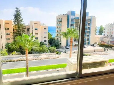 a window with a view of a street and palm trees at Samson Sea Breeze, 3bed sleeps 6, free WiFi in Limassol