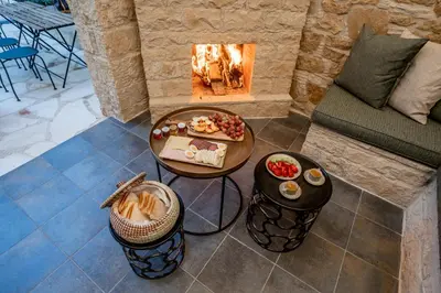 a living room with a fireplace and a table with food at Palazzino Luxury Suites in Lofou
