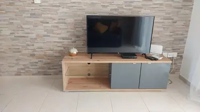 a television sitting on top of a wooden stand at Nissi Golden Sands Sunny Apartment A1D4 in Ayia Napa