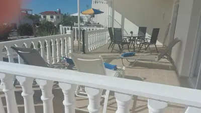 a balcony with chairs and tables on a house at Nissi Golden Sands Sunny Apartment A1D4 in Ayia Napa