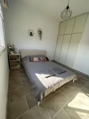 a bed in a bedroom with a tiled floor at Joanna Court rooms in Larnaka