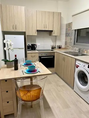 a kitchen with a table and a washing machine at INCREDIBLE VIEW in Larnaka
