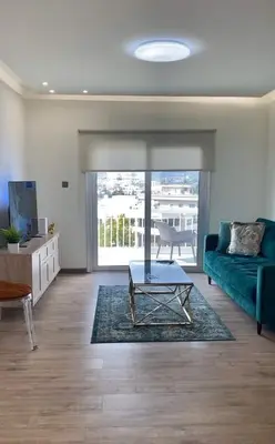 a living room with a green couch and a table at INCREDIBLE VIEW in Larnaka