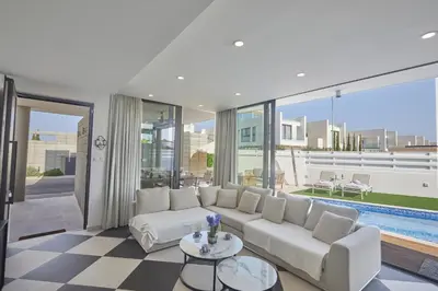 a living room with a white couch and a pool at Almaria Villas in Protaras
