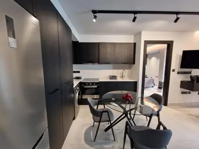 a kitchen with a table and chairs in a room at Raam Luxury Suites in Larnaka