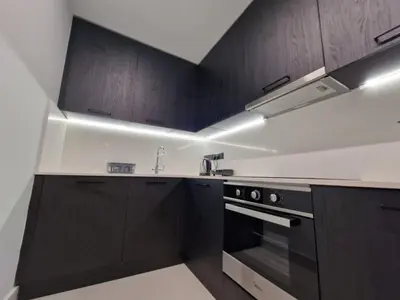 a kitchen with black cabinets and a stove at Raam Luxury Suites in Larnaka