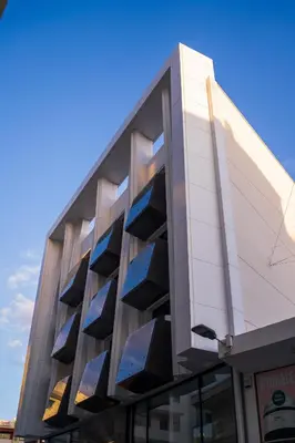a building with blue windows on the side of it at Raam Luxury Suites in Larnaka