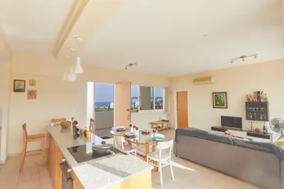 a kitchen and living room with a table and a couch at Spectacular Sea View, private jacuzzi & table pool in Protaras
