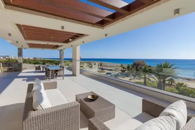 an outdoor patio with a view of the ocean at Palace of Mediterranean Beachfront Villa in Ayia Napa