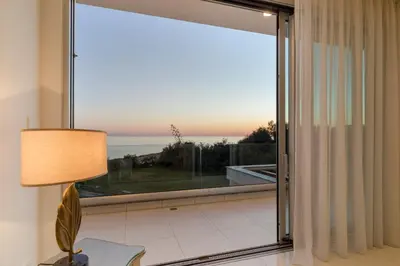 a large sliding glass door with a view of the ocean at Palace of Mediterranean Beachfront Villa in Ayia Napa