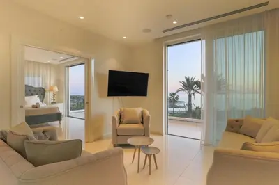 a living room with two couches and a tv at Palace of Mediterranean Beachfront Villa in Ayia Napa