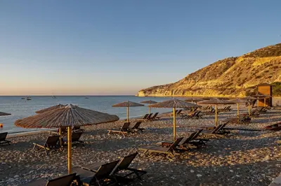 a group of chairs and umbrellas on a beach at Pissouri bay studio in Pissouri