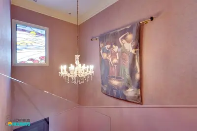 a painting hanging on a wall with a chandelier at Beachfront Villa Carpe Diem in Mor Menekshe