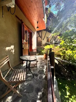 a patio with a table and a bench next to a building at GaliniCafe22-suites in Kakopetria