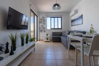 a living room with a couch and a table at Polyn 1- Bedroom Apartment in Larnaca in Larnaka