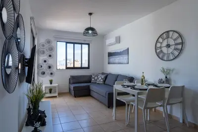 a living room with a blue couch and a table at Polyn 1- Bedroom Apartment in Larnaca in Larnaka
