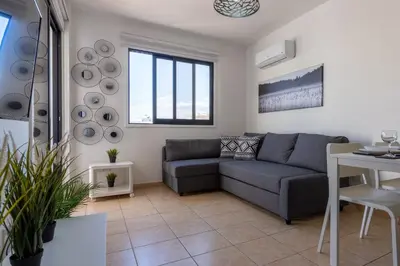 a living room with a couch and a table at Polyn 1- Bedroom Apartment in Larnaca in Larnaka