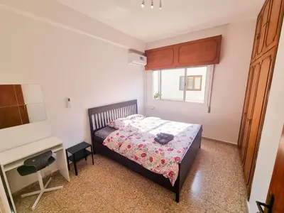 a bedroom with a bed and a desk and a window at Luxury City Rooms - Smart TV with Netflix in Larnaka