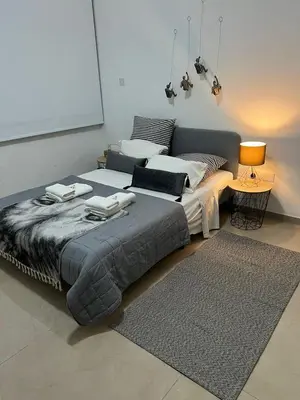 a bedroom with a large bed and a rug at HESTIA Studio Downtown Nicosia in Nicosia