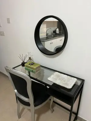 a glass table with a chair and a mirror at HESTIA Studio Downtown Nicosia in Nicosia