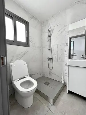 a white bathroom with a toilet and a sink at Nemesis Second floor studio in downtown Nicosia in Nicosia