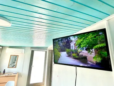 a flat screen tv in a room with a blue ceiling at Nemesis Second floor studio in downtown Nicosia in Nicosia