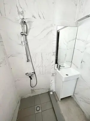 a white bathroom with a shower and a sink at Nemesis Second floor studio in downtown Nicosia in Nicosia