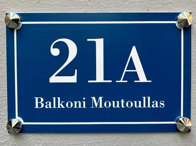 a blue sign on a wall with the number million at Balkoni Moutoullas in Moutoullas