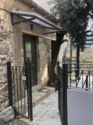 a gate to a stone house with a door and a tree at Balkoni Moutoullas in Moutoullas
