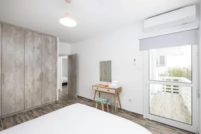 a bedroom with a large bed and a window at Happy Stay Apartment - Halefka Court in Larnaka
